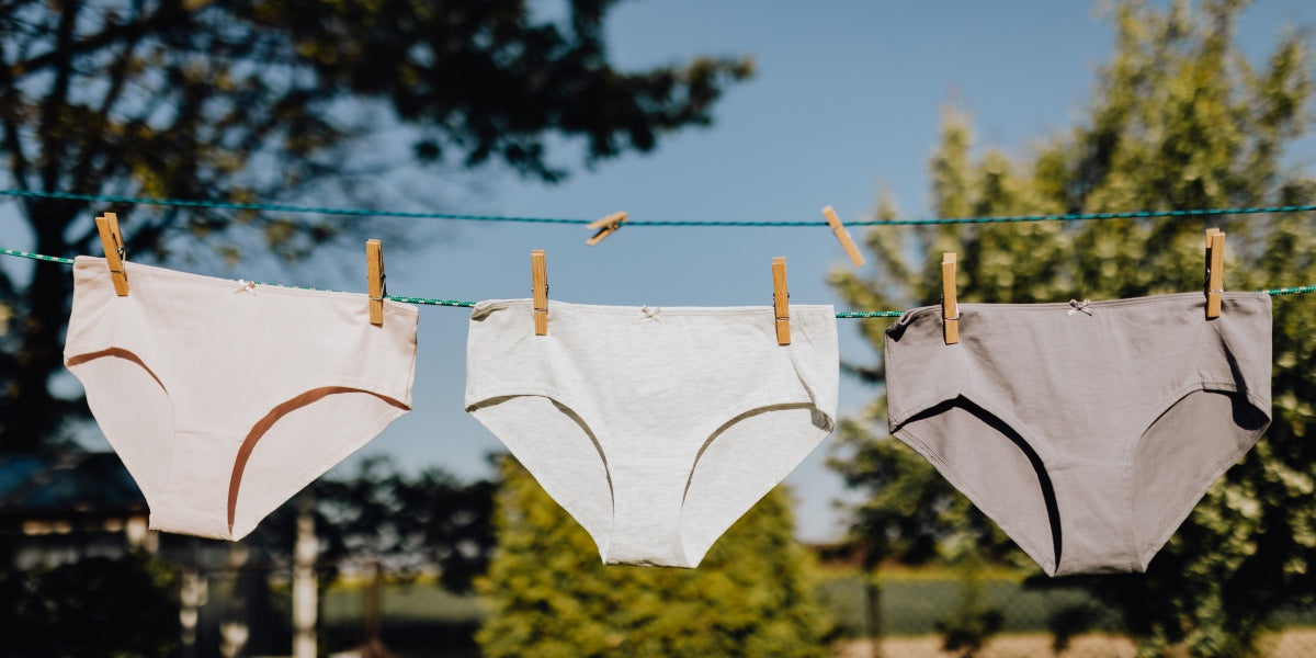 three pairs of panties air drying on a washing line